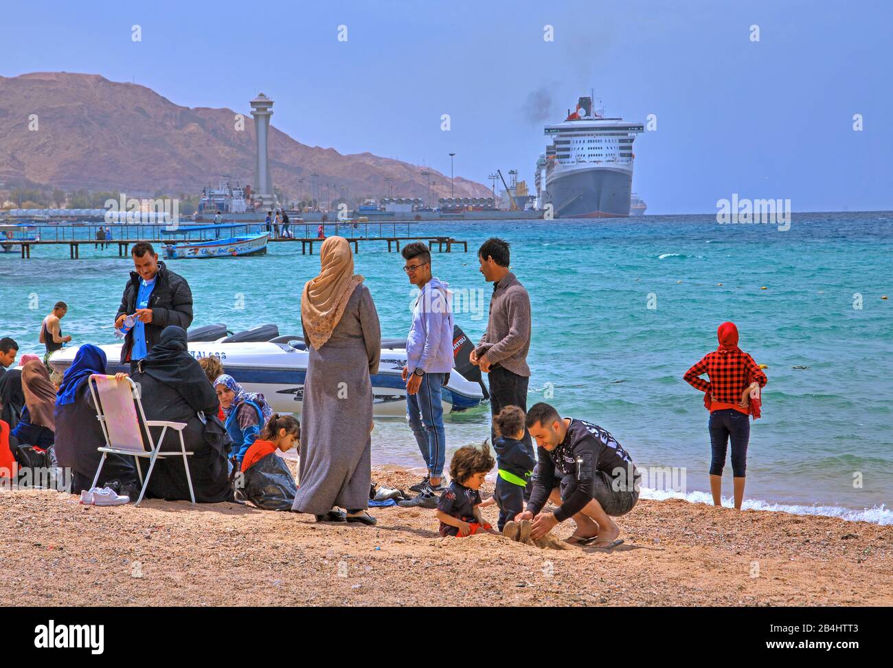 Les habitants de la plage de la ville avec vue sur le port d'Akaba Aqaba, le golfe d'Aqaba, la mer Rouge, la Jordanie Banque D'Images