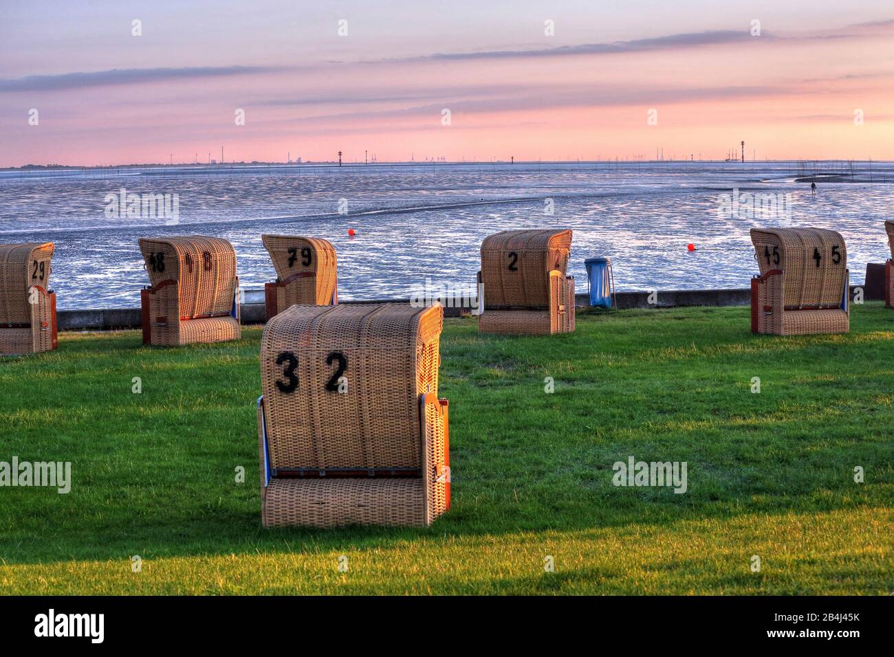 Plage d'herbe avec chaises de plage sur la mer des Wadden au soleil le soir, station balnéaire de la mer du Nord Wremen, Land Wursten, estuaire du Weser, mer du Nord, côte de la mer du Nord, parc national de la mer des Wadden de Basse-Saxe, Allemagne Banque D'Images