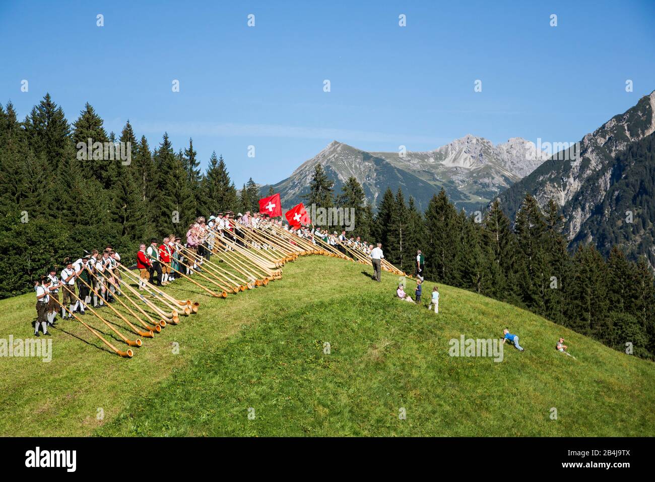 Autriche, Vorarlberg, petit Walsertal, Baad, Alphorn Festival, Alphorn souffleur, pré. Banque D'Images