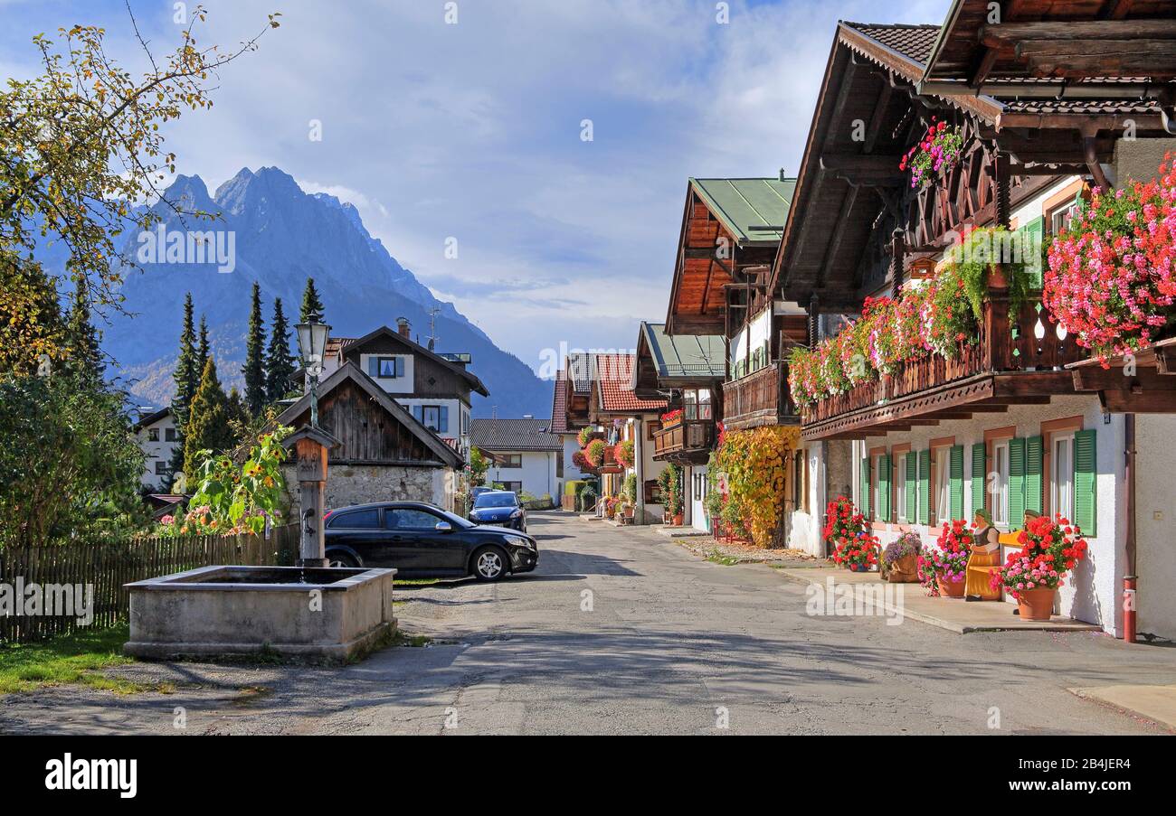 Maisons traditionnelles de campagne bavaroises avec balcons fleuris sur la route de printemps contre le Waxenstein (2277m), Garmisch-Partenkirchen, les montagnes de Wetterstein, Werdenfelser Land Haute-Bavière, Bavière, Allemagne Banque D'Images