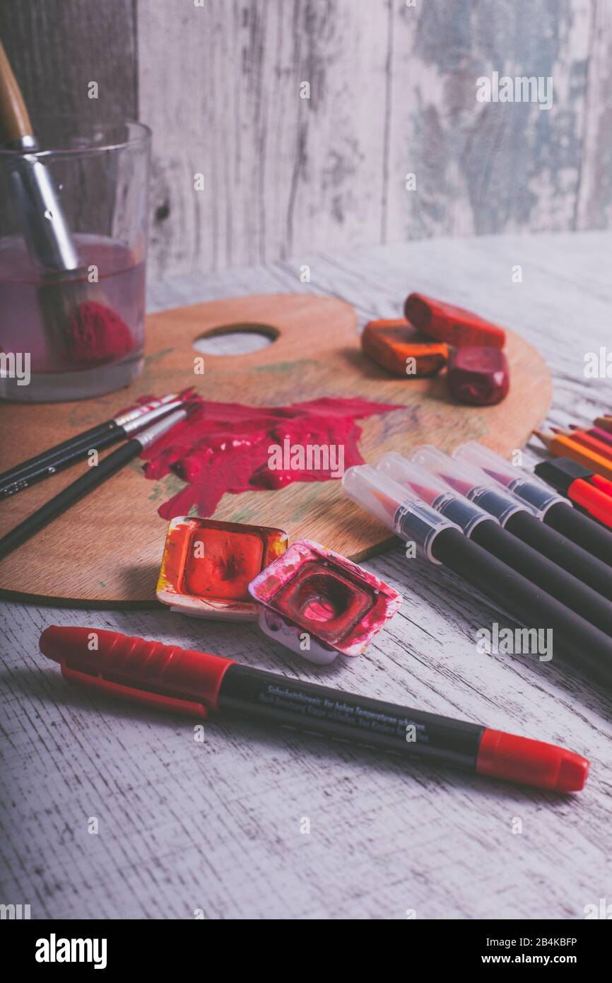 Disposition de divers stylos et ustensiles de peinture dans la couleur rouge Banque D'Images