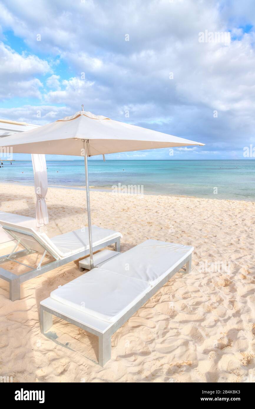 Chaises longues et parasol sur la plage de sable blanc de la côte des Caraïbes de Riviera Maya à Cancun, au Mexique. Banque D'Images