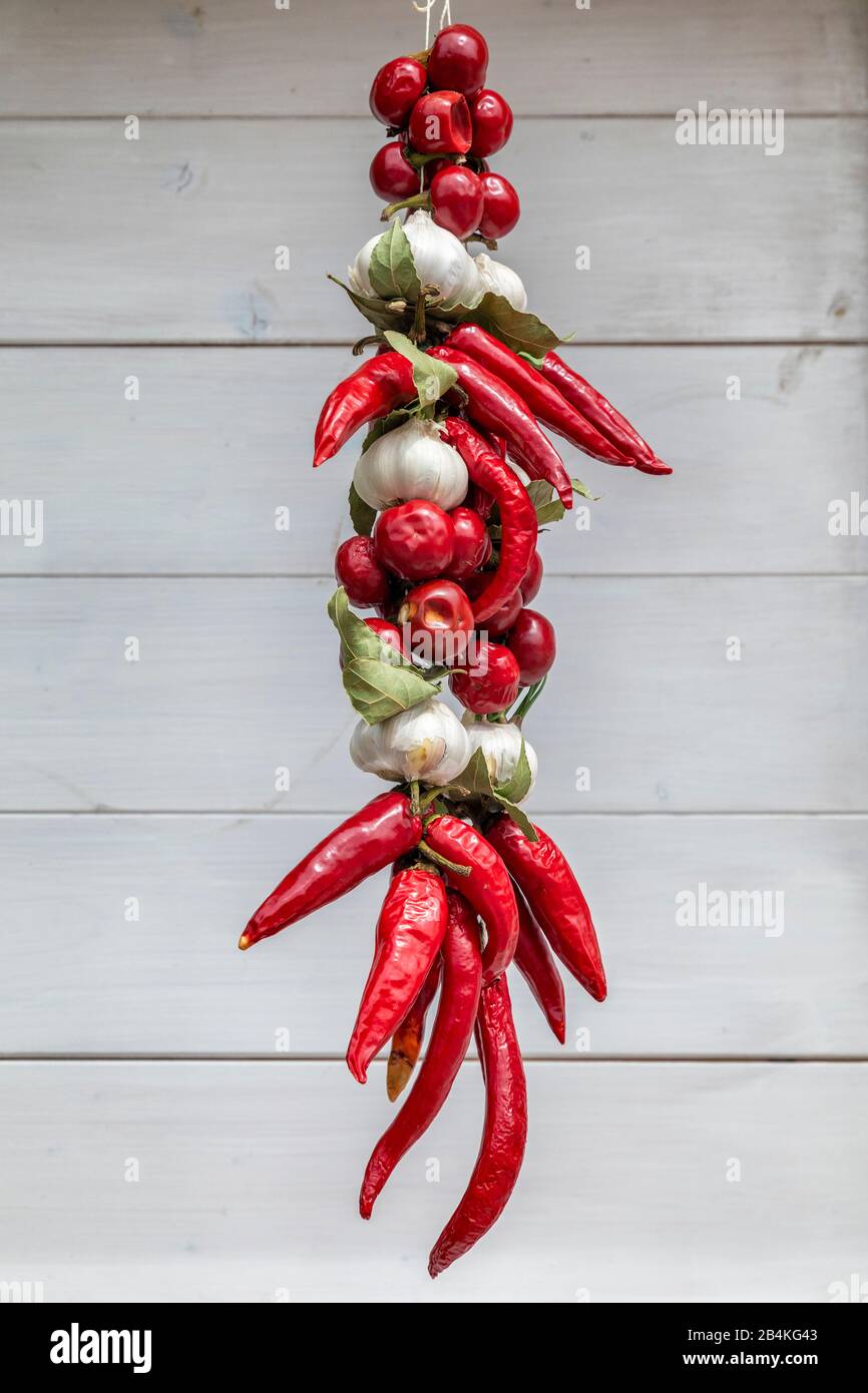 Tresse de poivrons chauds et d'ail accrochés dans un marché local de produits à Baska, île de Krk, baie de Kvarner, comté de Primorje-Gorski Kotar, Croatie Banque D'Images