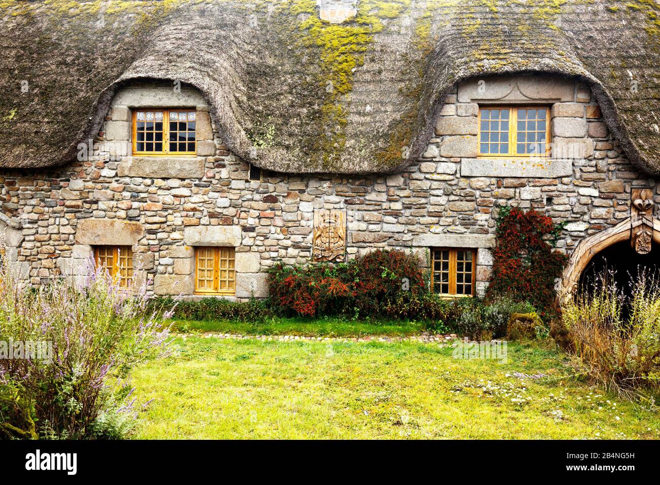 Chalet rustique en pierre avec toit de chaume. Fenêtre sous le toit. Ille-et-Vilaine, Bretagne Banque D'Images
