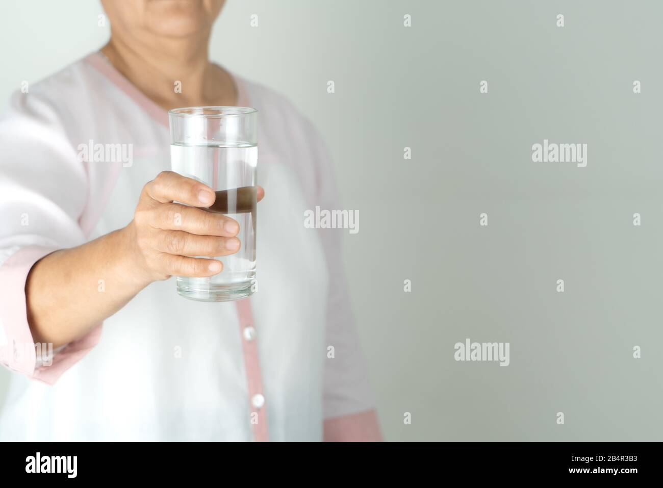 Eau potable dans la main de la femme âgée, concept de protection de l'environnement, boisson saine. Banque D'Images