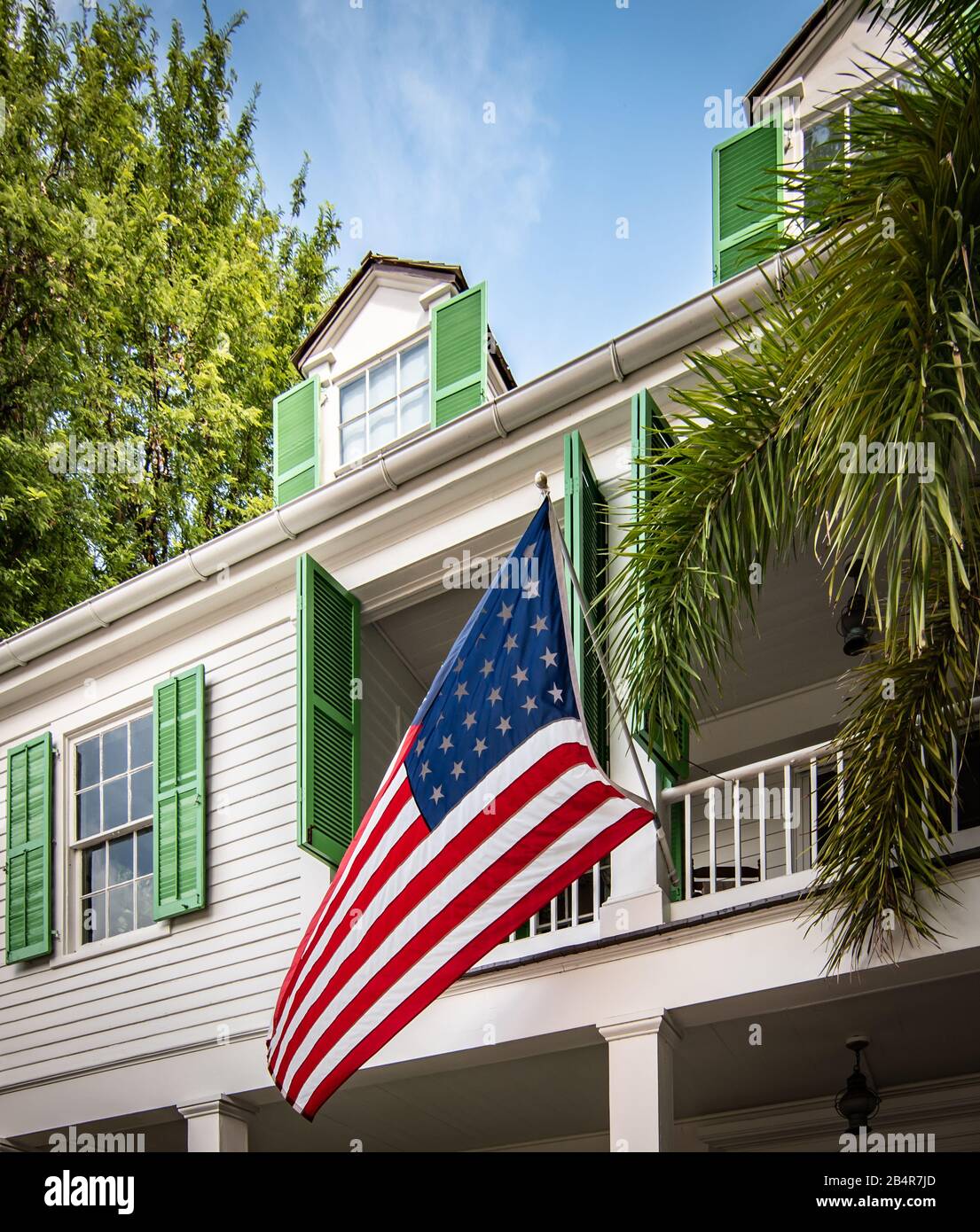 Drapeau américain devant une maison en bois à Key West, Floride. Banque D'Images