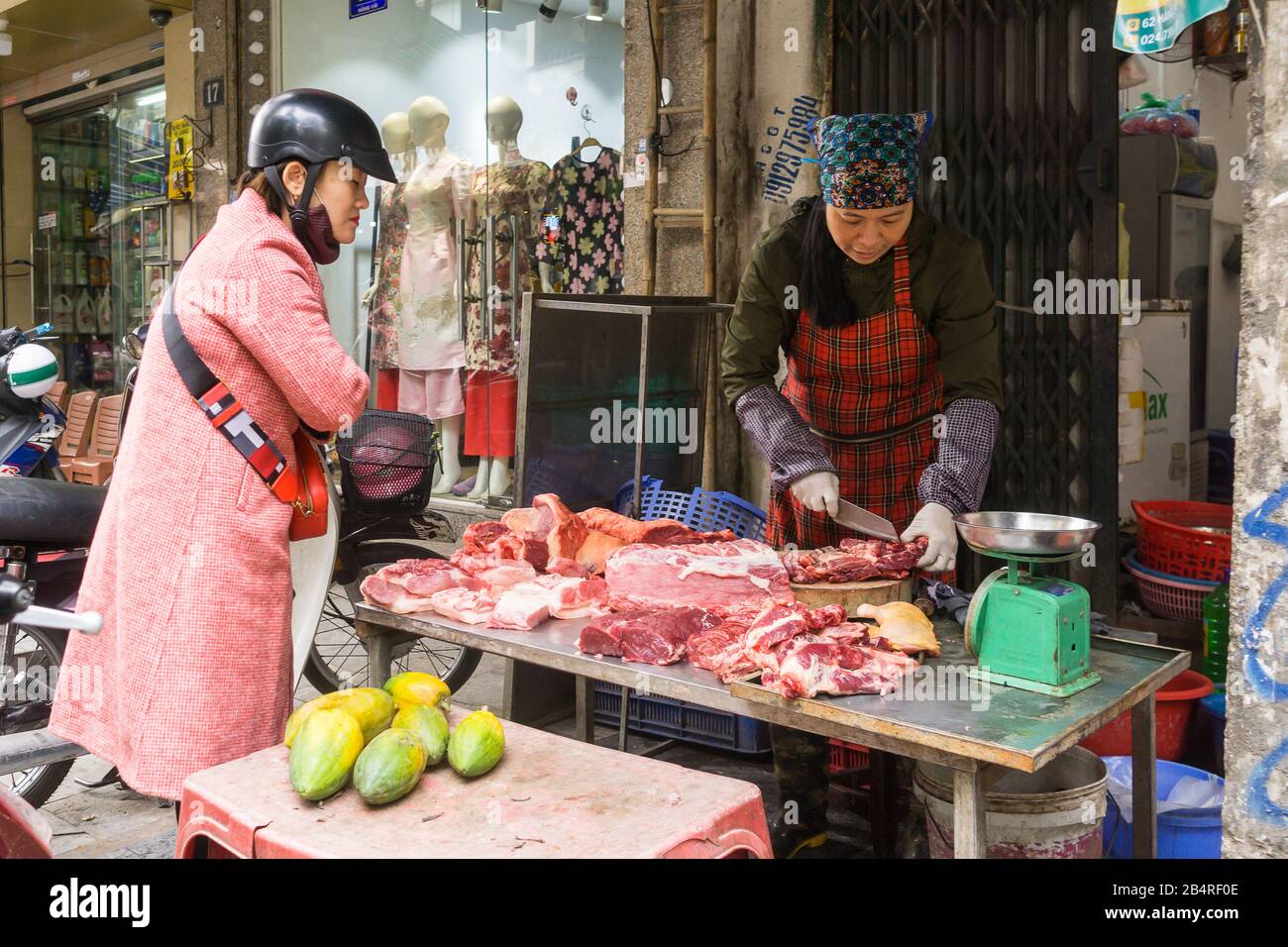 Scène de rue de Hanoi - une femme achetant de la viande crue dans la rue à Hanoi, Vietnam, Asie du Sud-est. Banque D'Images