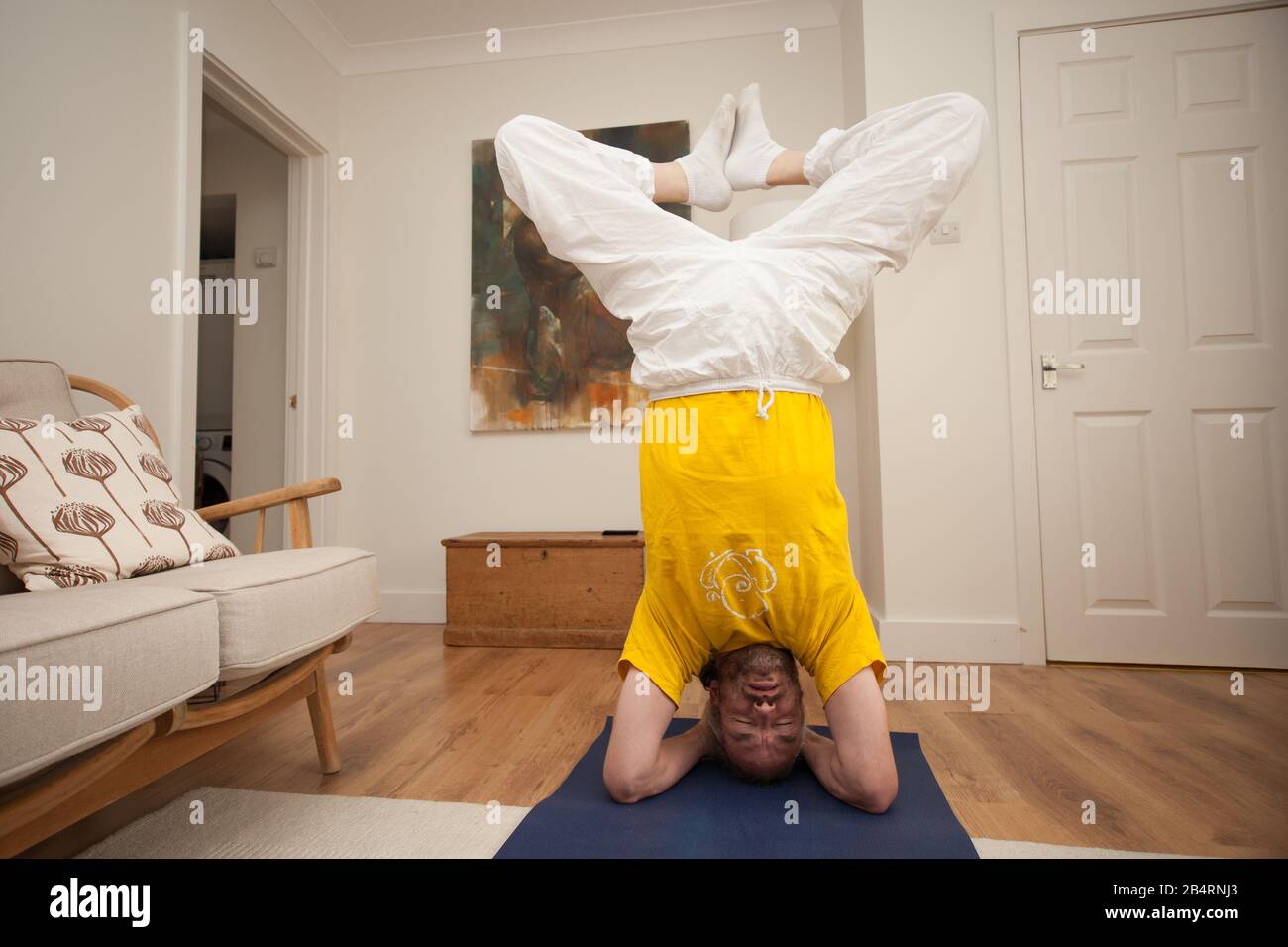 Un homme pratiquant le yoga à la maison Banque D'Images