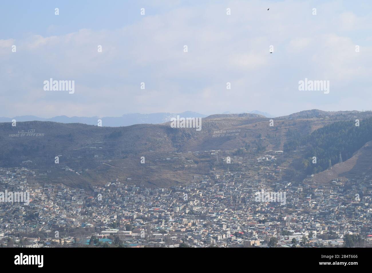 Vue sur la ville depuis le sommet de la montagne en journée ensoleillée avec arbres, lac et ciel bleu ciel nuageux Banque D'Images