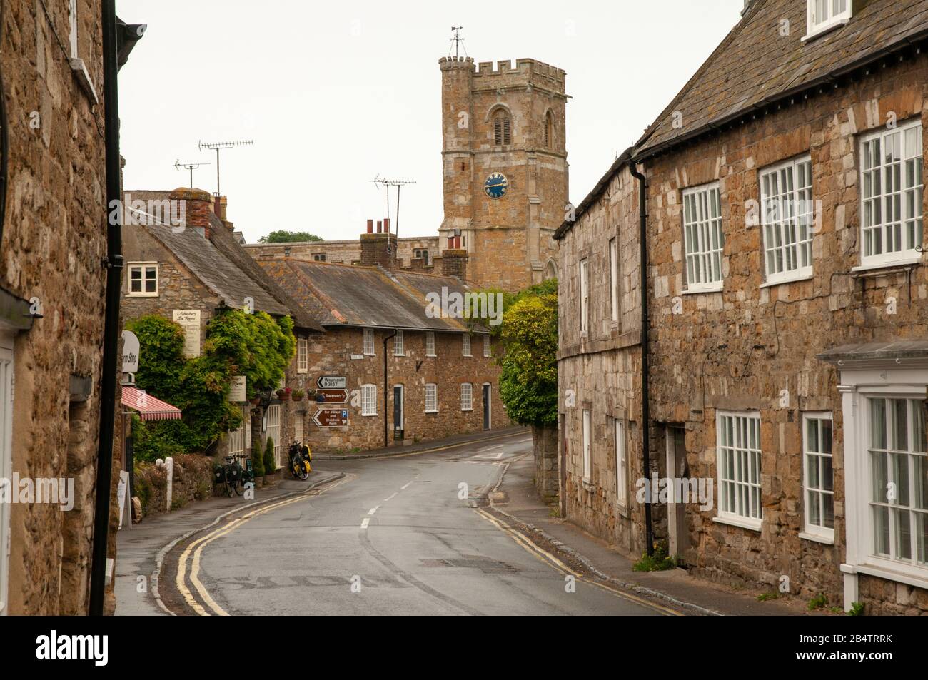 En regardant Market Street avec ses vieilles maisons en pierre vers l'église St Nicholas à Abbotsbury à Dorset, en Angleterre. Banque D'Images