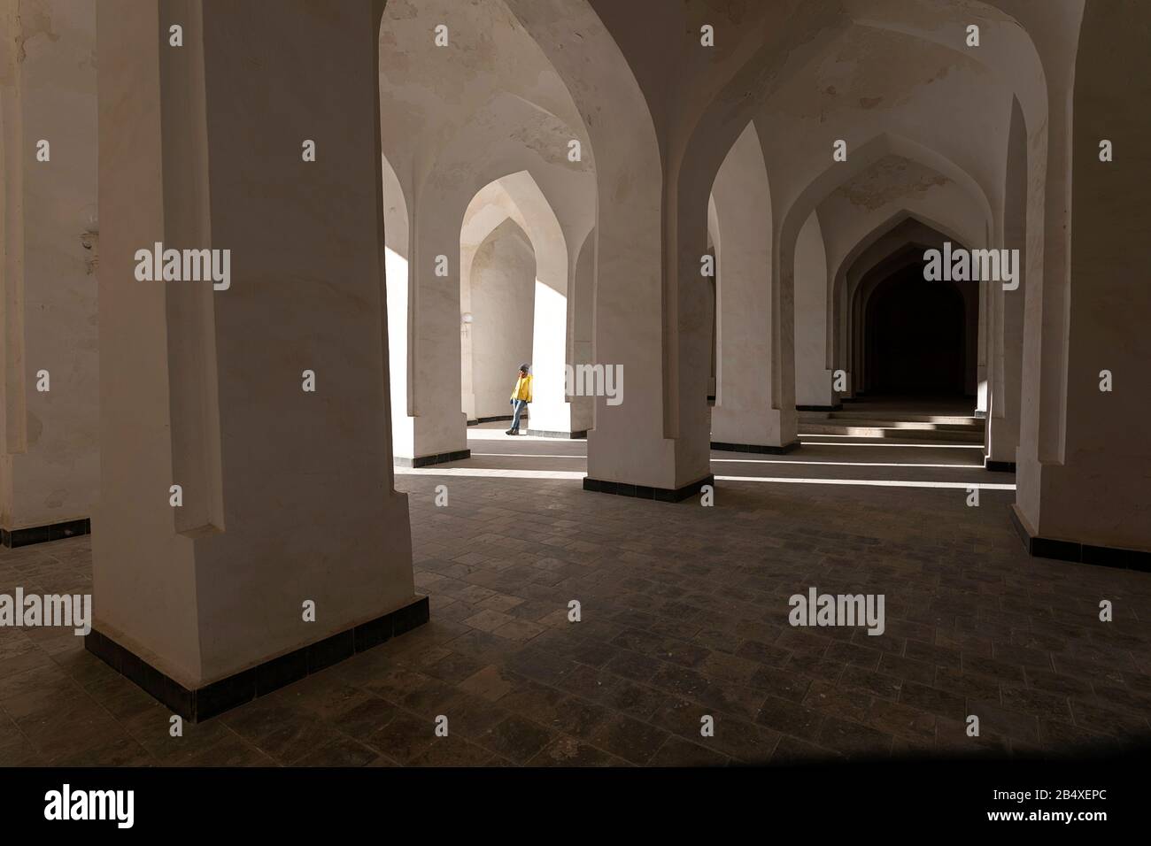 Femme debout dans une arche blanche, colonnes, intérieur de Kalan, Mosquée de Kalon, Boukhara, Bouchara, site du patrimoine mondial de l'UNESCO, Ouzbékistan, Asie centrale Banque D'Images