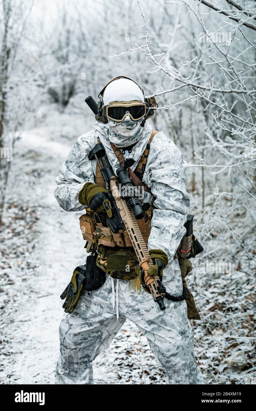 Airsoft homme en uniforme de camouflage blanc et machinegun avec vue  optique. Soldat dans le territoire forestier d'hiver fond. Photo verticale  Photo Stock - Alamy