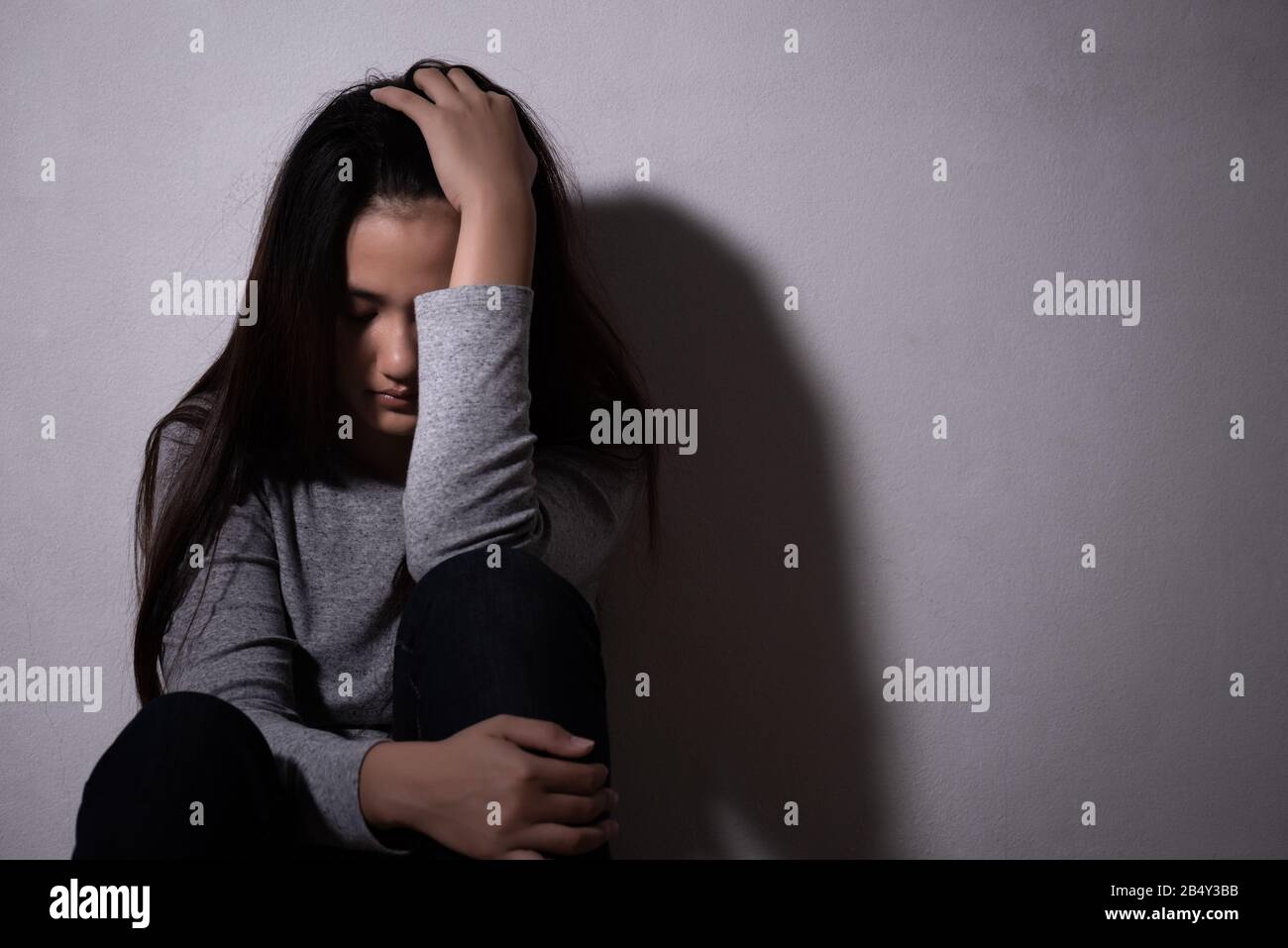 Femme Triste Hug Son Genou Et Pleurer Femme Triste Assise Seule Dans Une Salle Vide Photo Stock Alamy