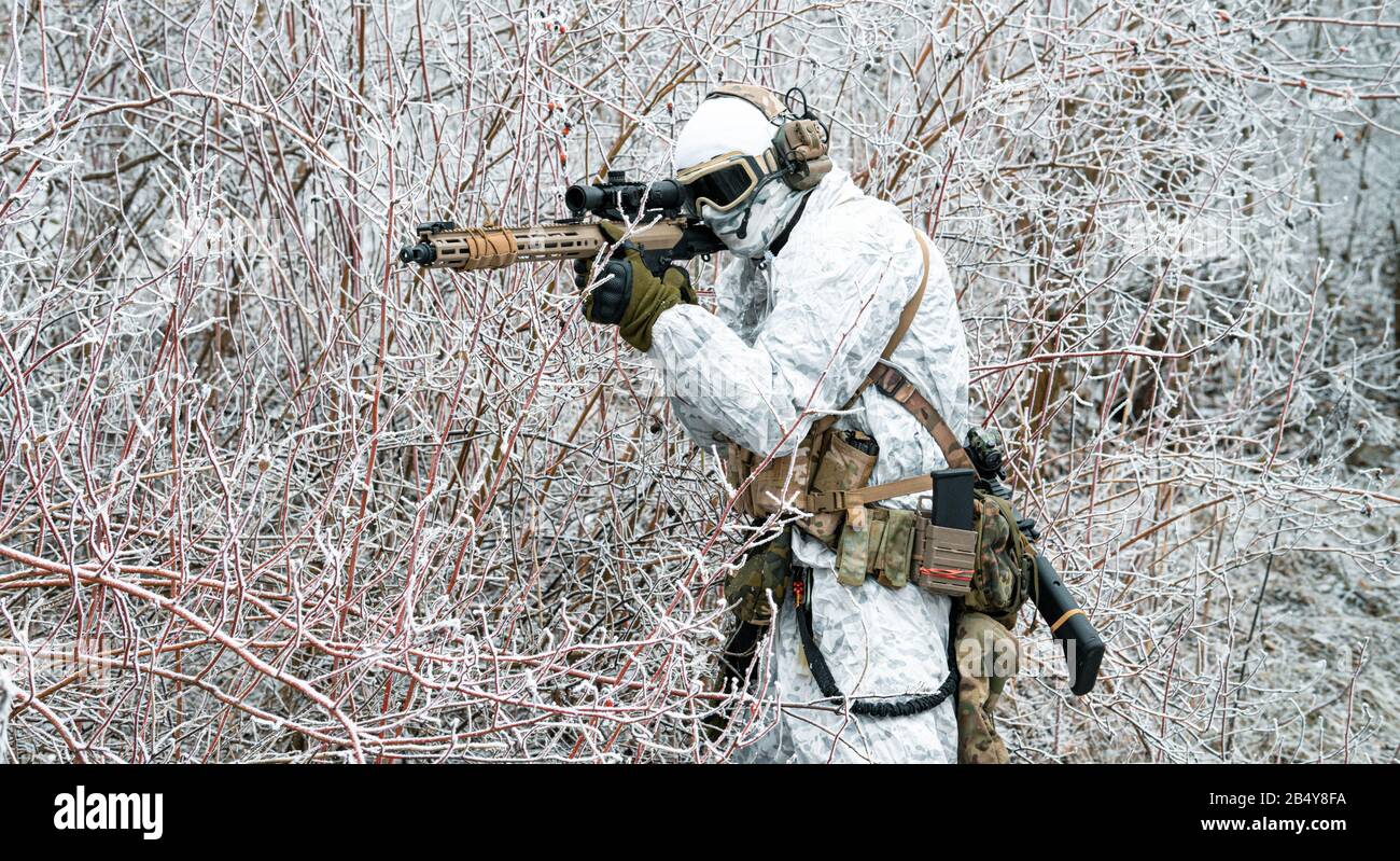 Airsoft homme en tenue de camouflage blanche avec machinegun. Soldat dans  la forêt d'hiver et vise à la vue de la machinegun. Vue latérale Photo  Stock - Alamy