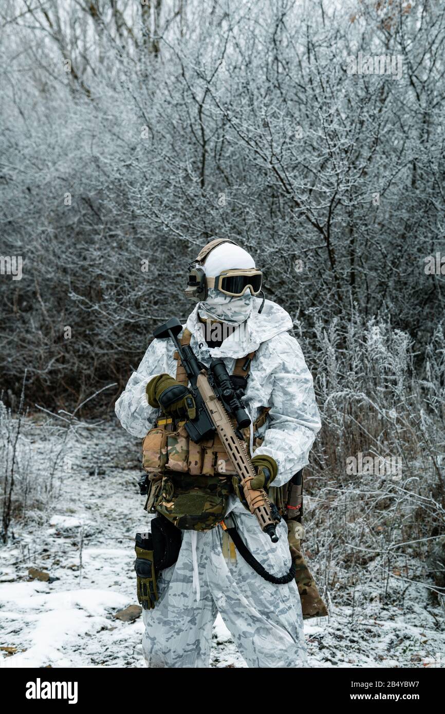 Militaire en uniforme de camouflage blanc avec machinégun. Soldat dans le  territoire forestier d'hiver fond Photo Stock - Alamy