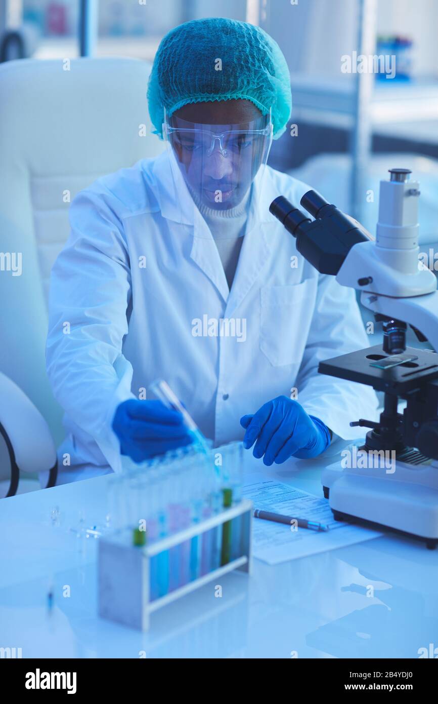 Scientifique Masculin Intelligent Regardant Sous Microscope Testant Et  Analysant Des échantillons De Virus Dans Une Boîte De Pétri