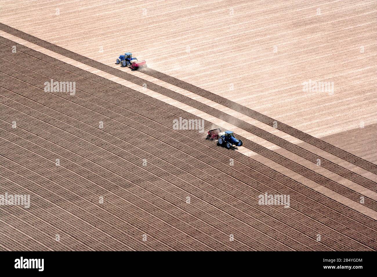 Vue aérienne de deux tracteurs travaillant dans le domaine de l'ensemencement. Une excellente image d'arrière-plan avec beaucoup de zone à copier. Banque D'Images