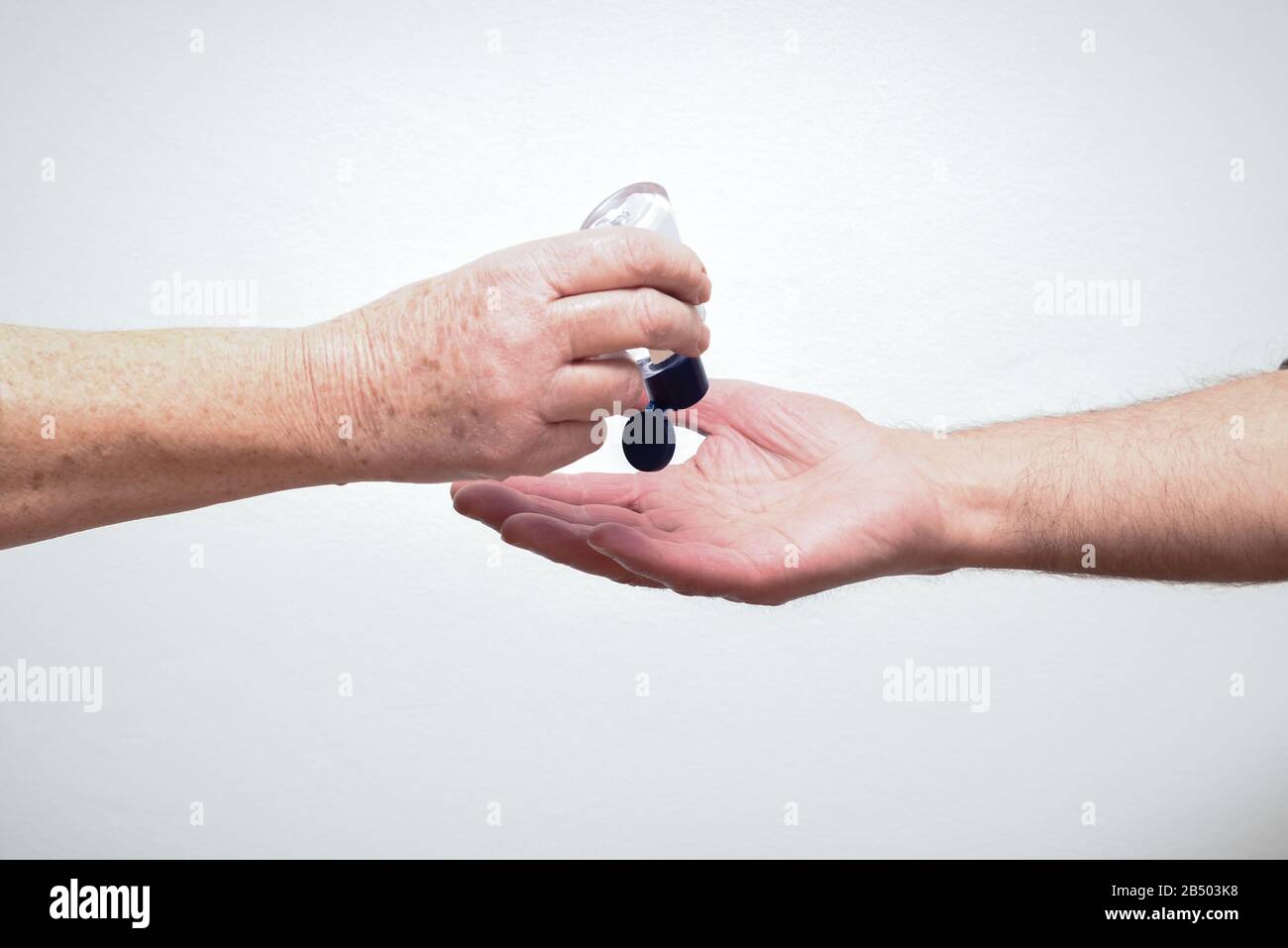 Les personnes qui utilisent et partagent du gel désinfectant pour les mains pour limiter la propagation du virus et de la maladie Banque D'Images