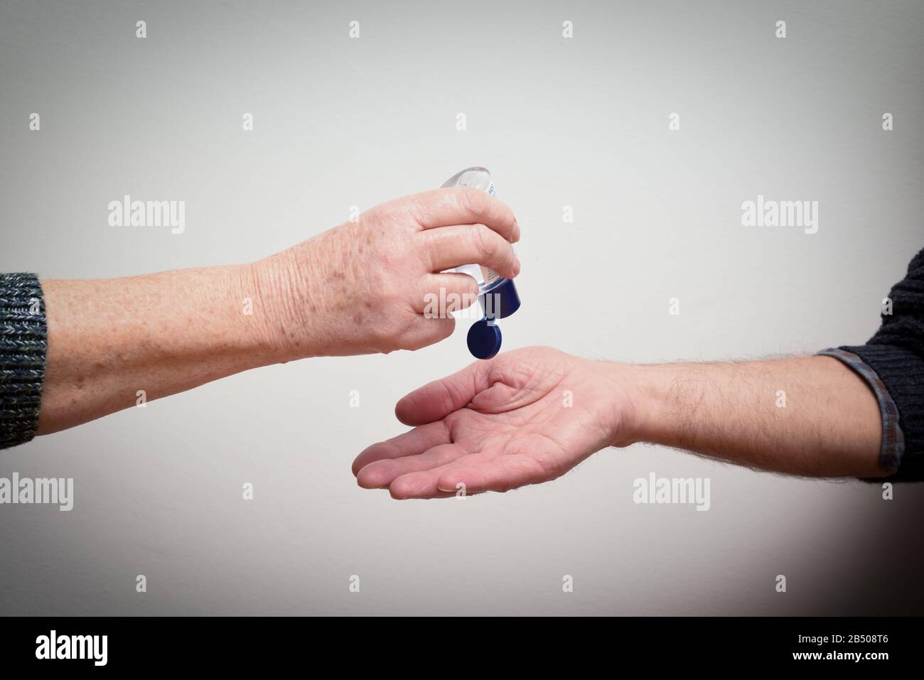 Les personnes qui utilisent et partagent du gel désinfectant pour les mains pour limiter la propagation du virus et de la maladie Banque D'Images