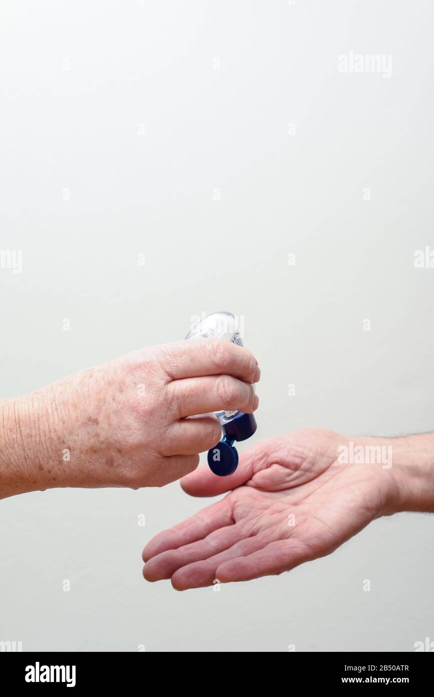 Les personnes qui utilisent et partagent du gel désinfectant pour les mains pour limiter la propagation du virus et de la maladie Banque D'Images
