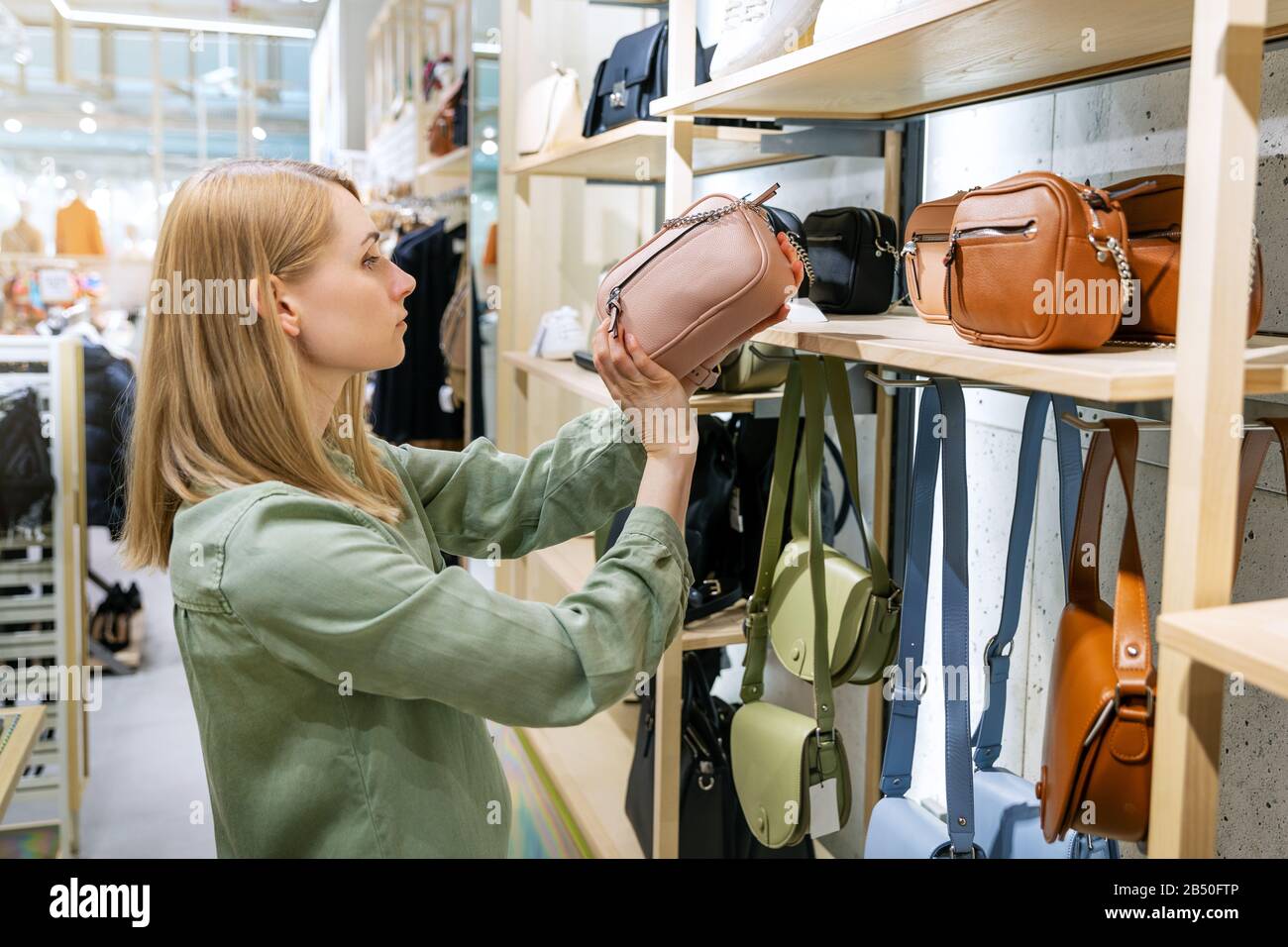 femme à la recherche d'un nouveau sac à acheter dans la boutique d'accessoires Banque D'Images