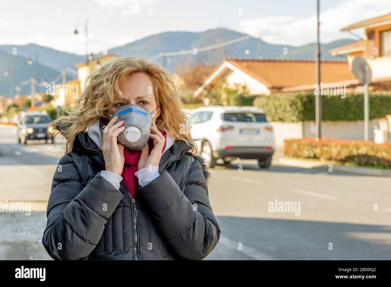 La femme blanche marche la rue avec le masque de protection à l'époque du coronavirus 'Covid - 19' qui touche de nombreuses personnes Banque D'Images