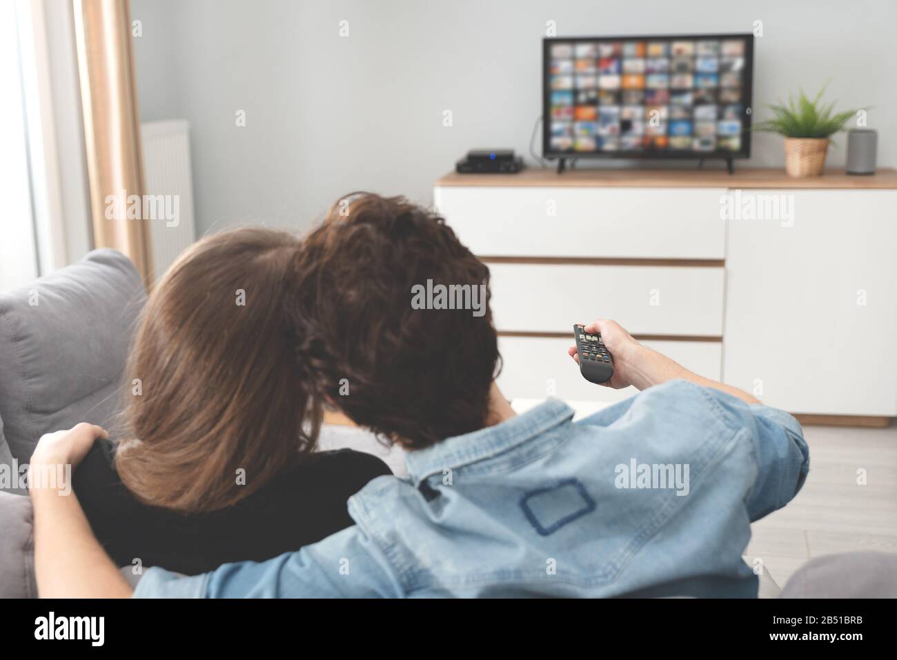 Couple regardant la télévision sur le canapé. Télévision, multimédia, concept de loisirs Banque D'Images