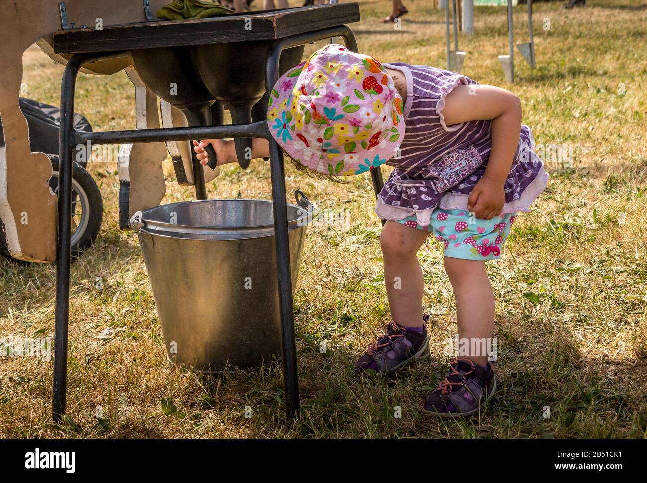 Auning, Danemark - 26 maj 2018 : ancien marché agricole d'Estrup, petite fille qui tente de faire du lait sur un simulateur de vache Banque D'Images