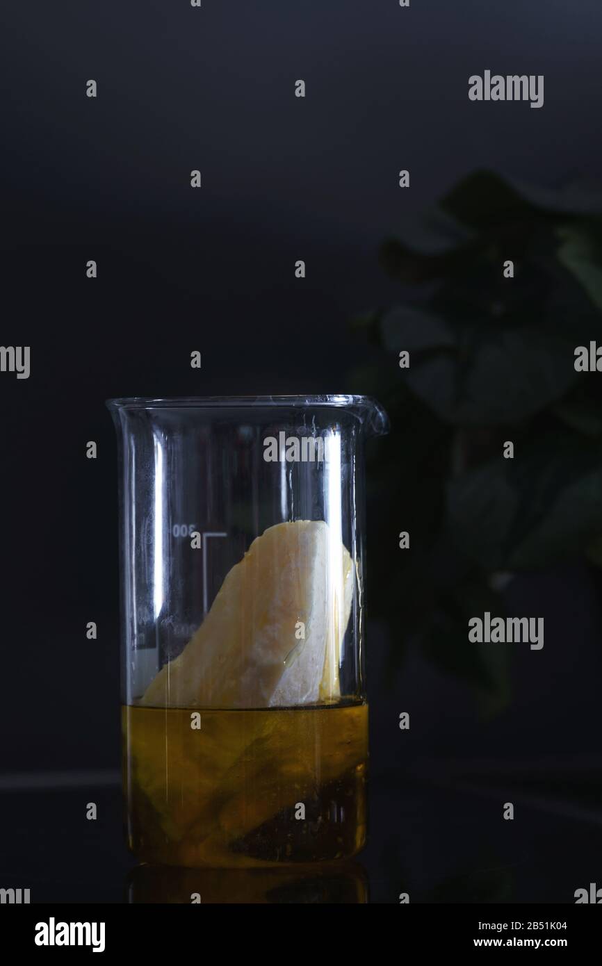 Beurre solide et huile à base végétale mélangé dans une fiole en verre sur la surface de la poêle en céramique Banque D'Images