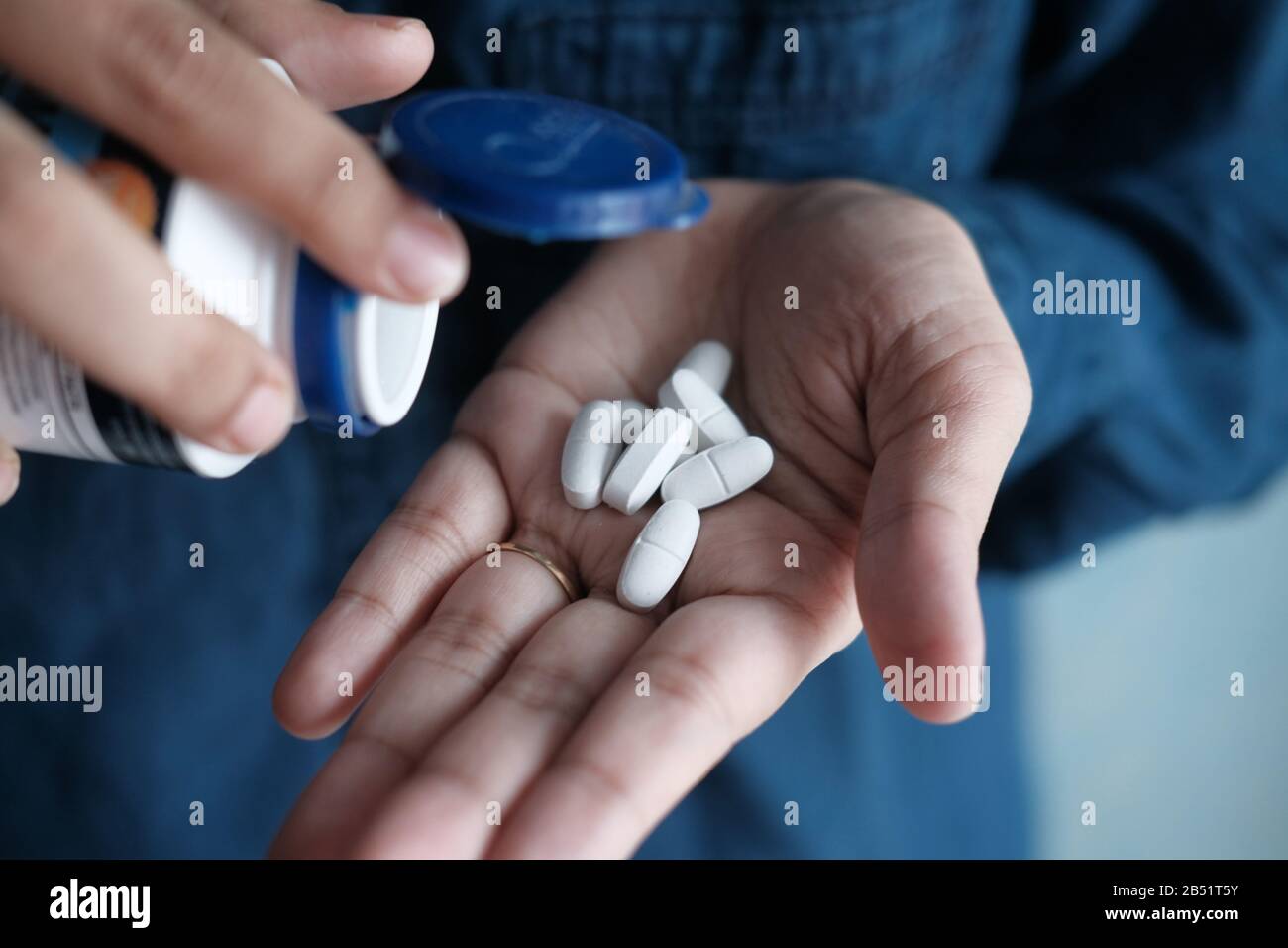 Verser les pilules de la bouteille blanche dans la main . Banque D'Images