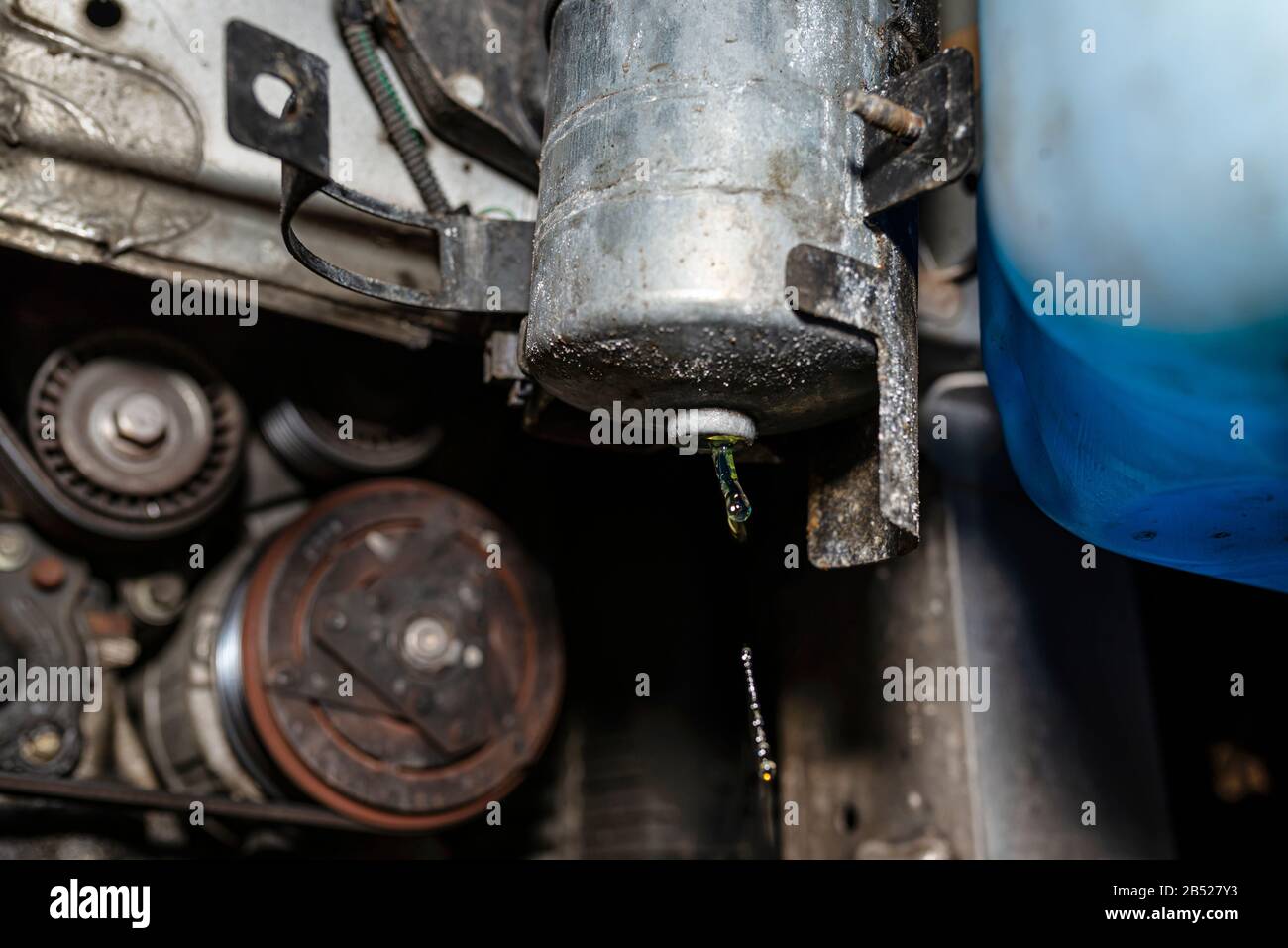 Filtre à carburant usé installé dans la voiture dans le passage de roue, qui goutte du carburant visible depuis le bas du filtre. Banque D'Images