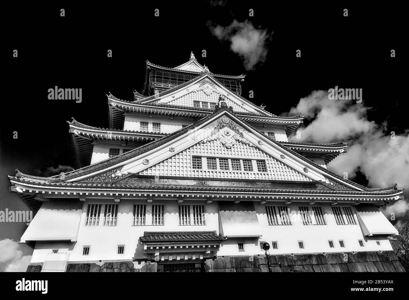 Façade noire-blanche contrastée de la spectaculaire tour historique du château à Osaka ville du Japon contre ciel clair. Banque D'Images