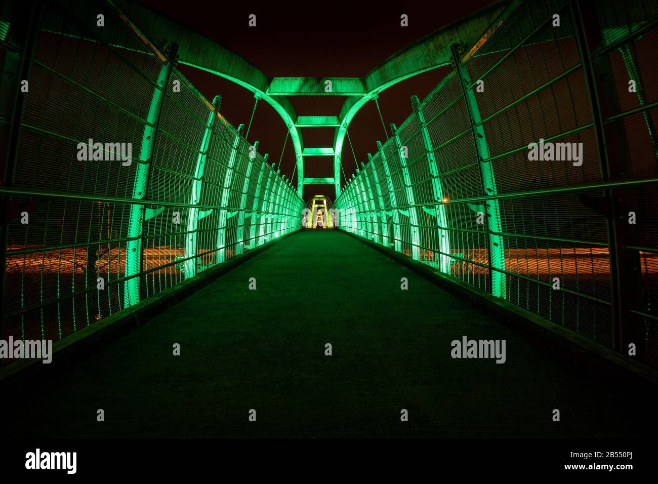 Des LED vertes éclairent la passerelle piétonne au-dessus de l'autoroute la nuit Banque D'Images