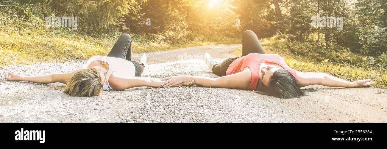 Meilleures femmes amis allongé sur la route de montagne au coucher du soleil - Filles Heureuses ayant l'amusement ensemble - amitié, amour, style de vie et concept de sisterhood - Foc Banque D'Images