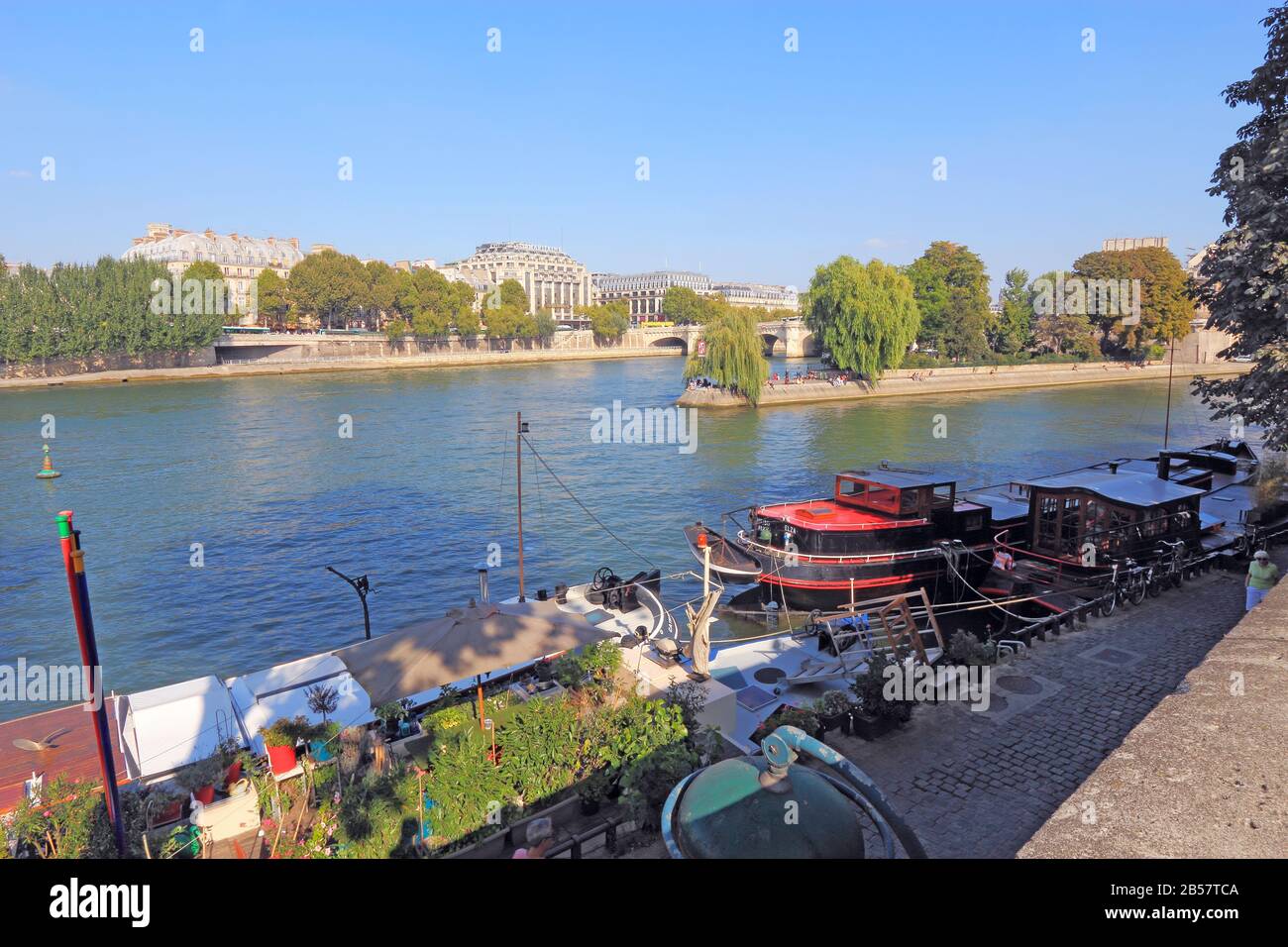 Barges et bateaux à moteur près de Pont neuf et de l'Ile de la Cité sur la rive gauche de la Seine. Beaucoup de ces bateaux sont des locations de touristes populaires. Banque D'Images