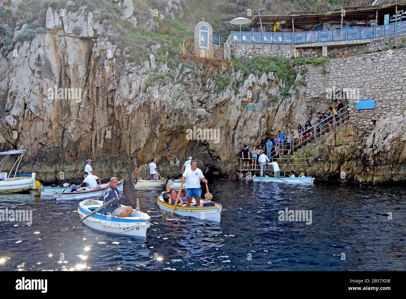 Touristes en petits bateaux attendant d'entrer dans la célèbre Grotte bleue sur l'île de Capri. Les conducteurs tirent les bateaux par une petite ouverture. Banque D'Images