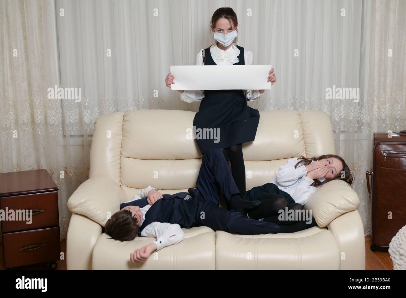 coronavirus covid-19 concept de quarantaine épidémique de trois petites familles d'enfants en uniforme scolaire et masque médical avec bannière d'espace de copie Banque D'Images