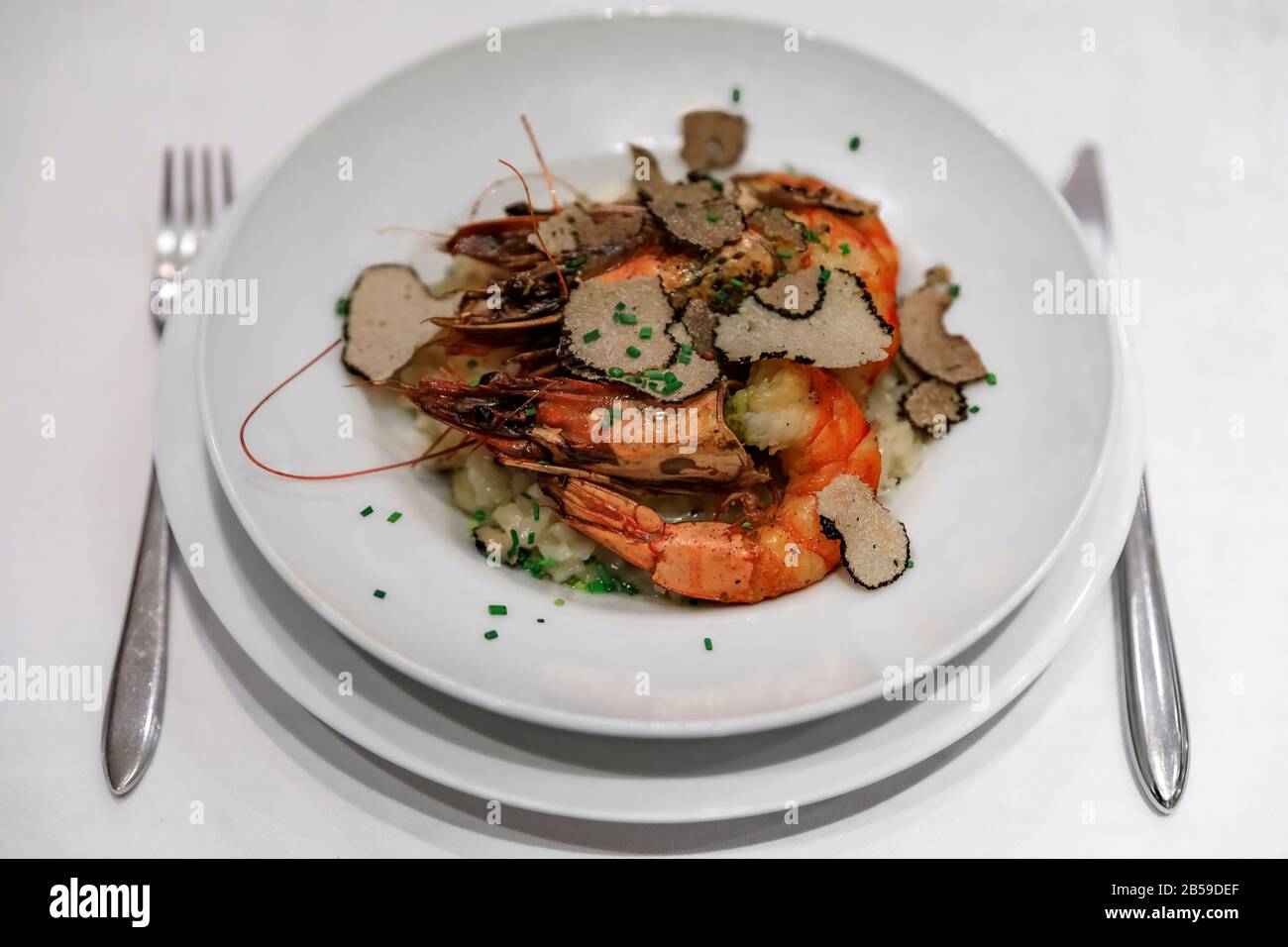 Des tranches de truffes noires rasées sur un risotto aux assiettes avec des  crevettes grillées entières servies dans un restaurant de luxe à Nice,  France Photo Stock - Alamy