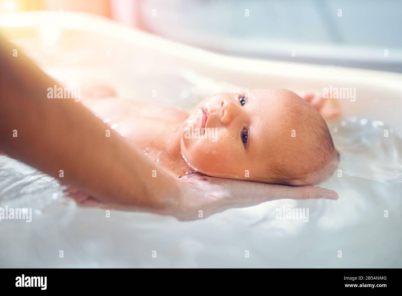 Petit Joli Grand Eyed Beau Bebe Baigne Dans L Eau Chaude Dans Les Mains D Une Mere Bienveillante Le Concept De La Garde De Bebe Et De La Garde D Enfants Photo Stock Alamy