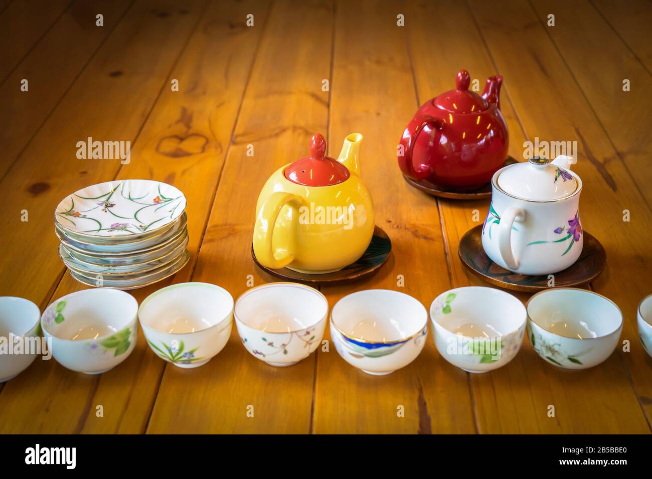 Thé blanc et rouge jaune sur la table en bois avec plat blanc et tasse dans la première rangée d'entre eux. Banque D'Images
