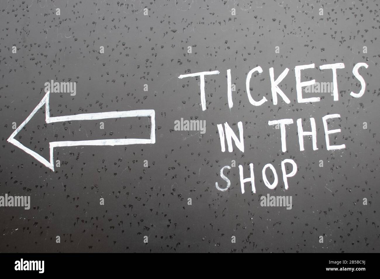 L'inscription Billets dans la boutique avec une flèche vers la gauche. Inscription Chalk sur tableau noir avec pointeur Banque D'Images