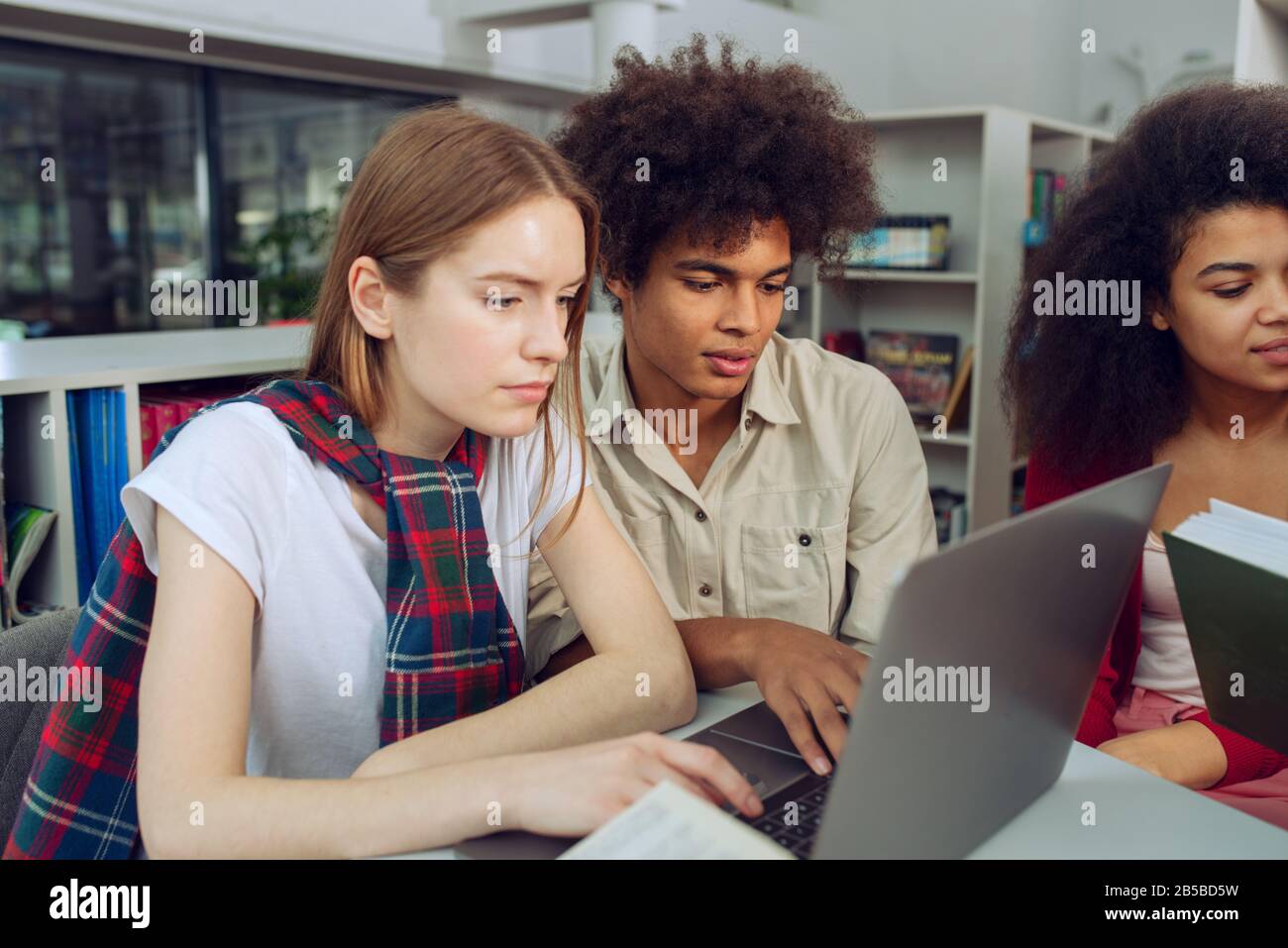 Les étudiants universitaires étudient dans une bibliothèque ensemble. Concept d'équipe et la préparation Banque D'Images