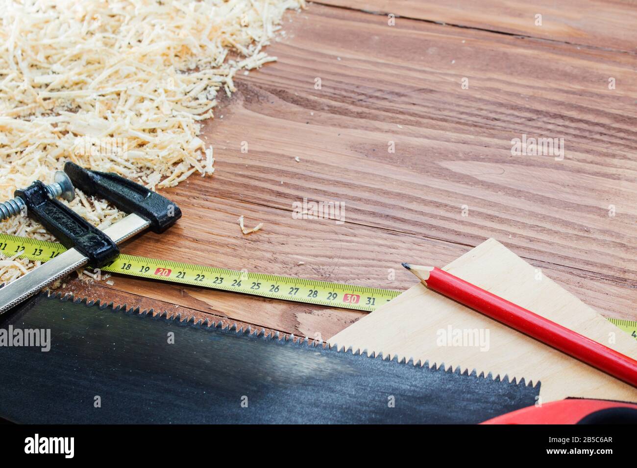 de nombreuses briques en bois pleines de sciure. Sur une table en bois rayée, concept d'outils de travail. Banque D'Images