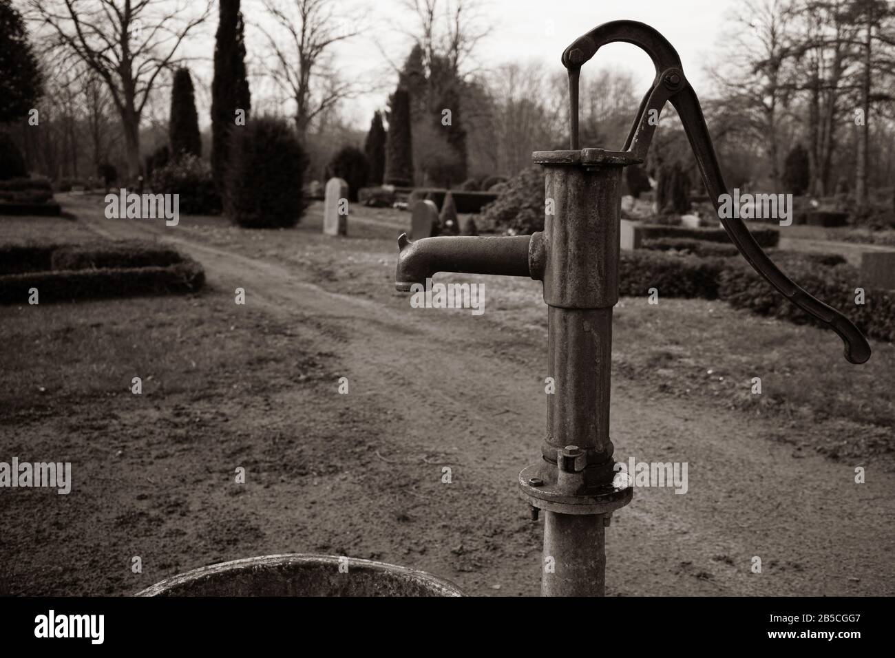 une ancienne pompe à eau en fonte se tient sur un cimetière Photo Stock