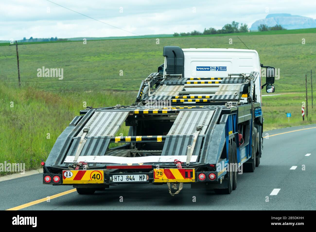 Camion à plateau vide et remorque circulant sur une route nationale dans une zone rurale d'Afrique du Sud concept voiture assistance routière Banque D'Images