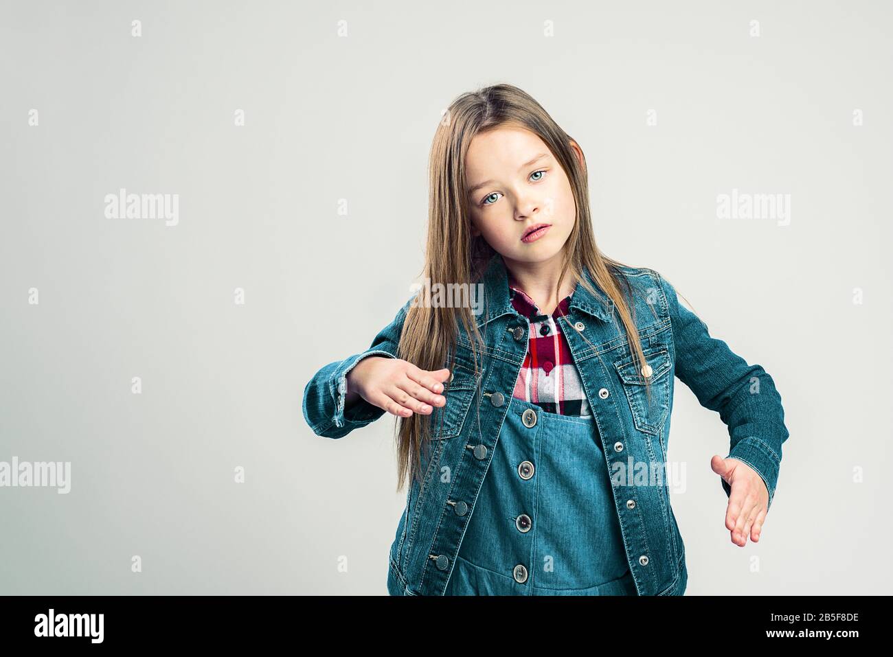 petite fille dépeint un robot. enfant pose dans le studio et fait des mouvements avec ses mains et ses pieds. mode enfants Banque D'Images