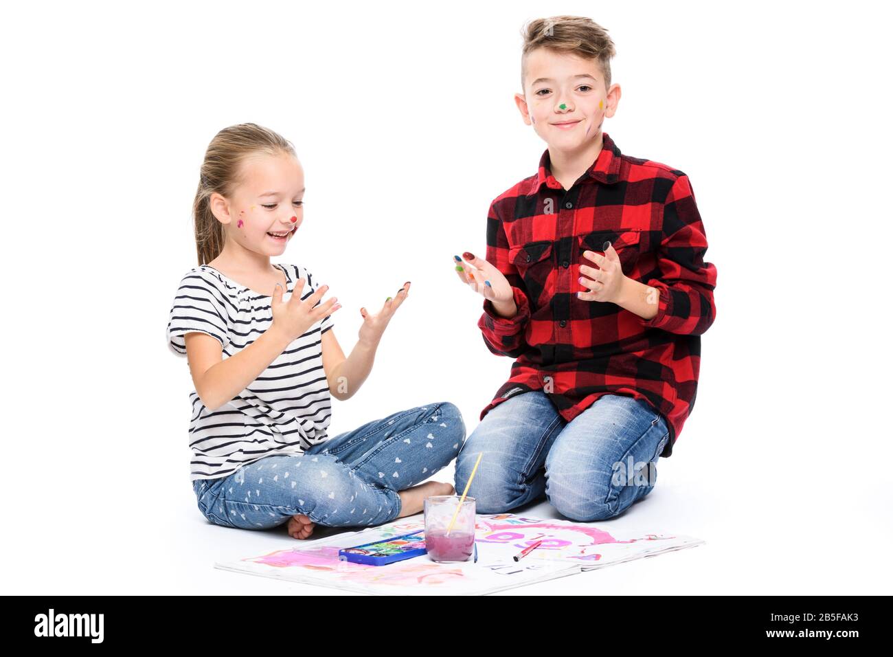 Frère et sœur s'amuser avec la peinture à l'aquarelle. Heureux enfants créatifs à la classe d'art. Concept art-thérapie sur fond blanc. Banque D'Images
