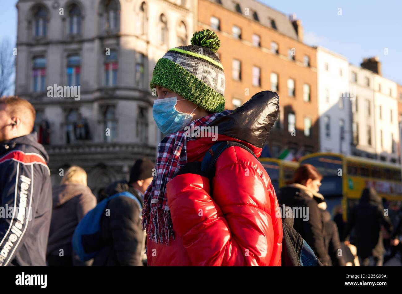 Un garçon portant un masque facial lors de l'épidémie mondiale de Coronavirus à Dublin, en Irlande. Banque D'Images
