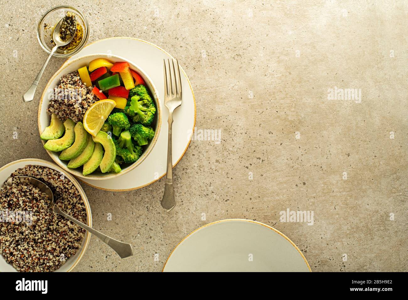 Repas de salade sain avec quinoa, avocat et légumes frais mélangés sur fond gris vue de dessus. Alimentation et santé. Concept de repas sain Banque D'Images