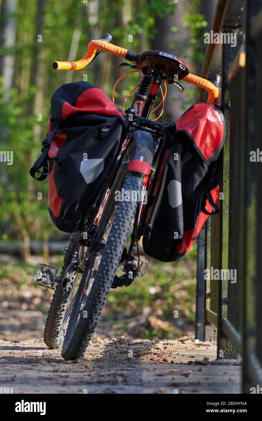 Helsinki, Finlande – 27 avril 2019 : vélo d'aventure avec vélo de montagne et capacités de vélo de tourisme et valises rouges attachées au vélo sur le pont. Banque D'Images